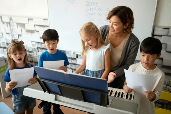 music education language development ดนตรีกับภาษา: ภาพเด็กกำลังร้องเพลงหรือพูดในชั้นเรียนดนตรี เน้นการพัฒนา ทักษะการฟังดนตรี