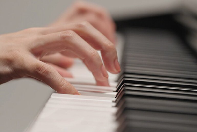 yamaha ydp-146r yamaha ydp-146wh 11 - mustore close-up of hands playing a piano keyboard, pressing white and black keys. - mustore