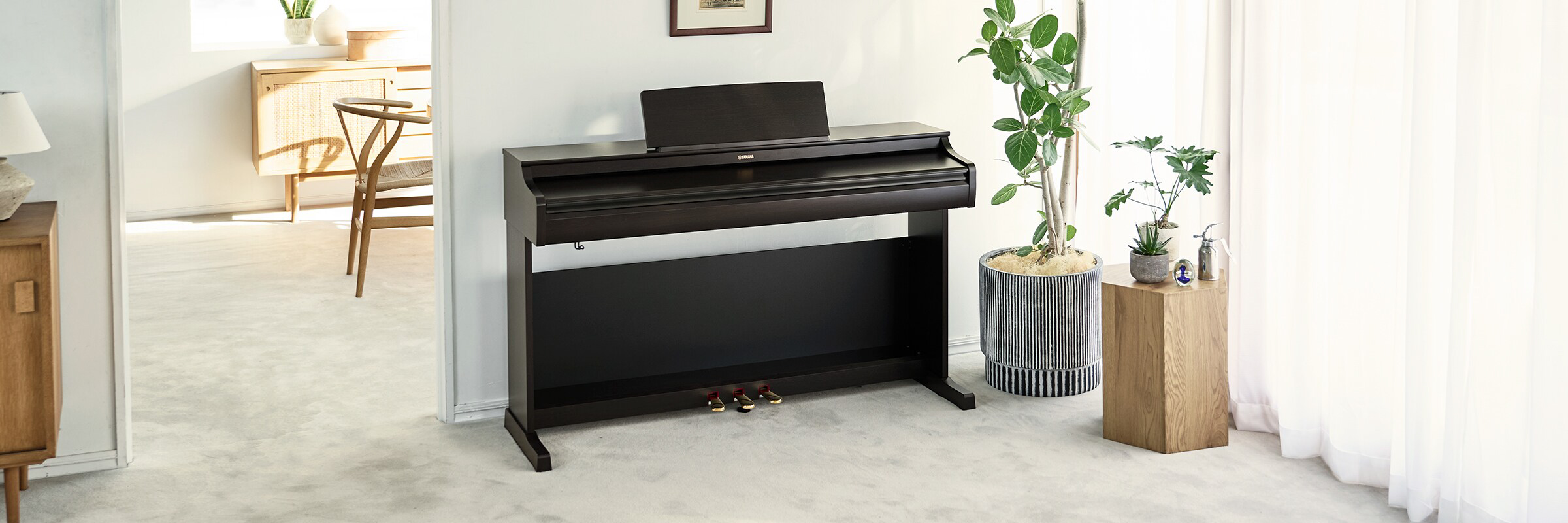 yamaha ydp-166r yamaha ydp-166wh 14 Black Yamaha digital piano in a bright living room, with a plant and light wood furniture nearby.