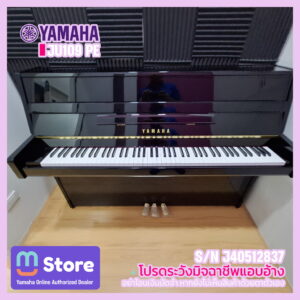 Yamaha upright piano in a showroom with keyboard visible and bold Yamaha branding on the front panel.