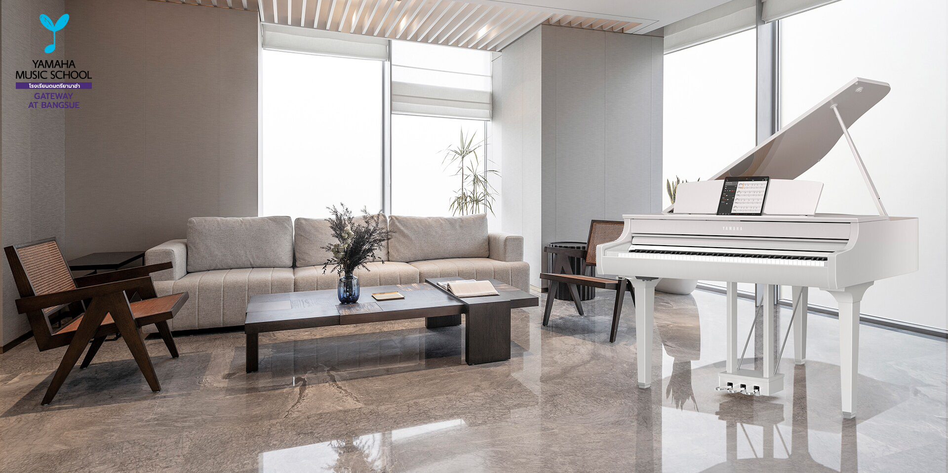 Bright modern living room with a white Yamaha grand piano by large windows, gray sofa, and wooden chairs.