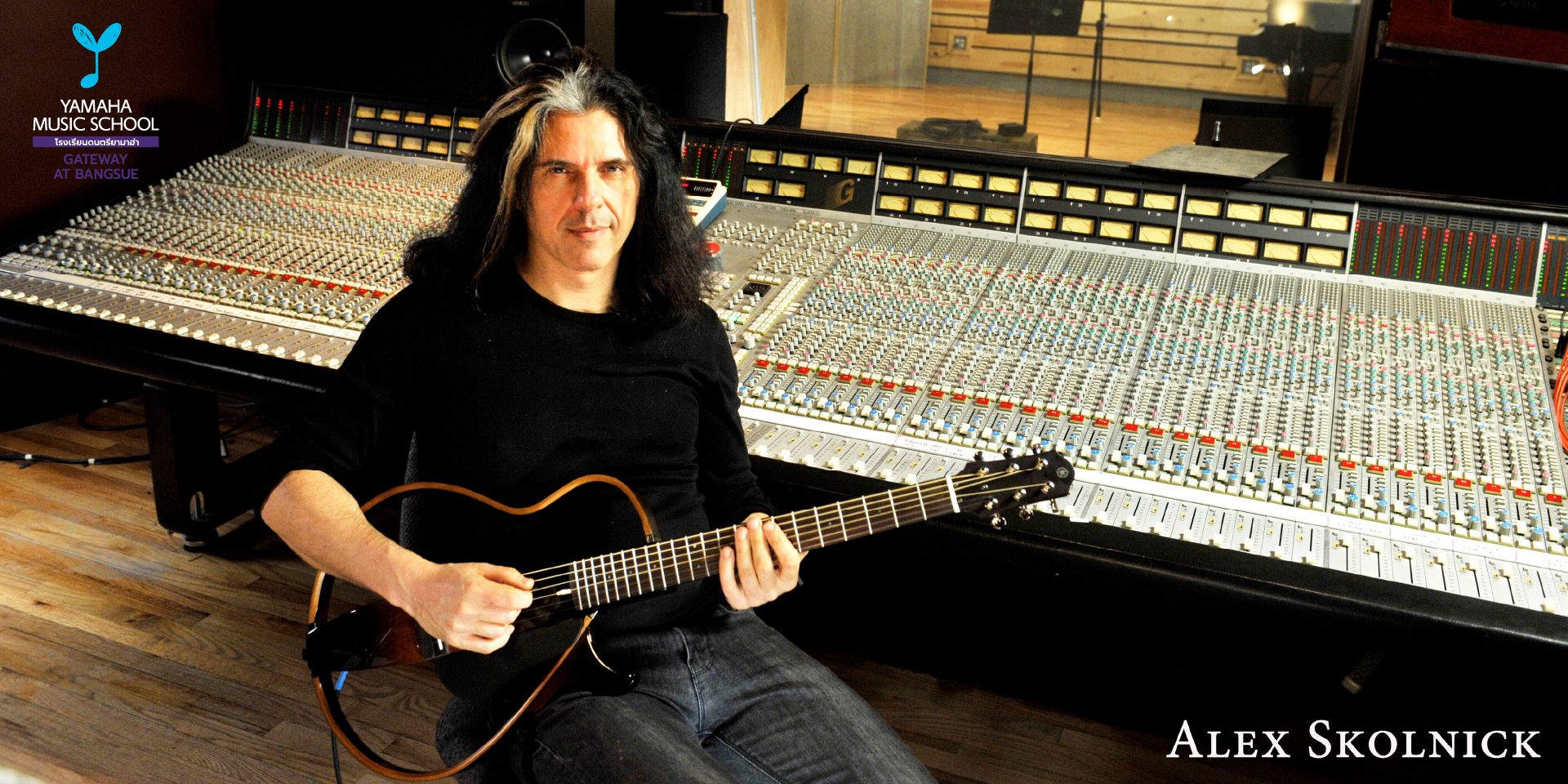 Alex Skolnick sits with an electric guitar in a large recording studio beside a massive mixing console, Yamaha Music School logo visible on the left.