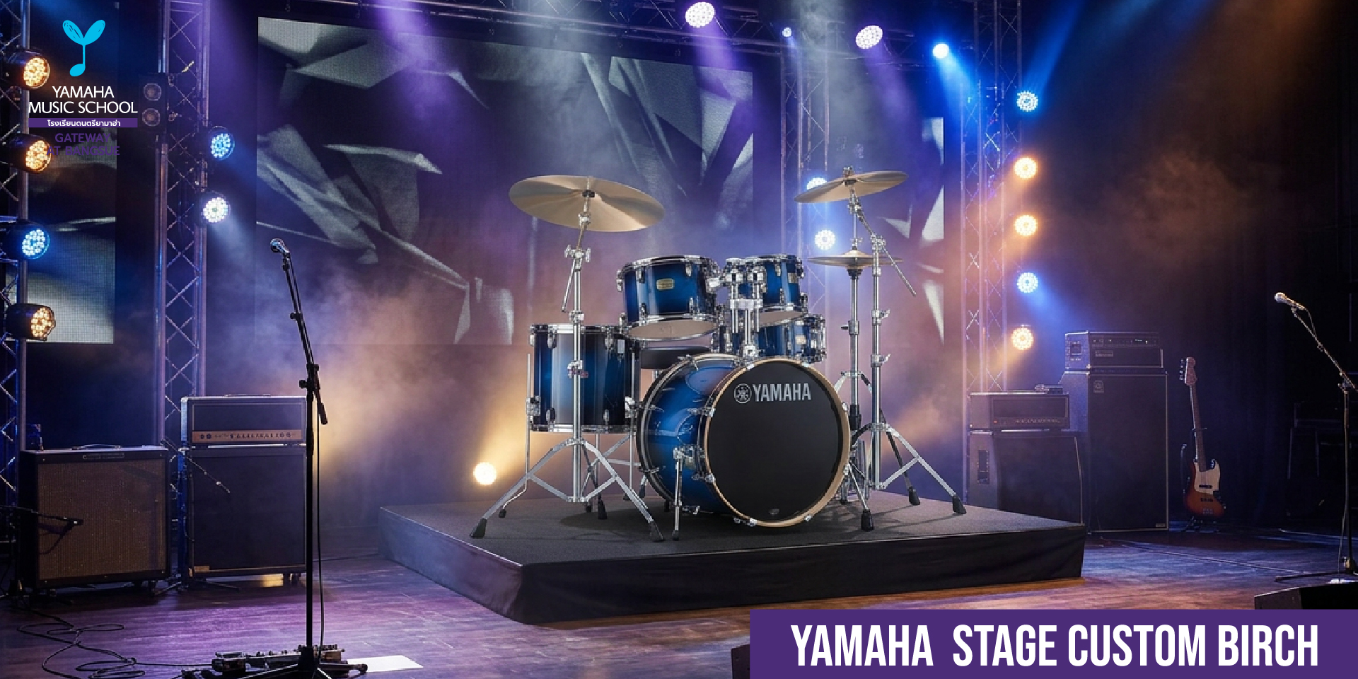 Blue Yamaha Stage Custom Birch drum kit on a lit concert stage with microphones and amplifiers around it for a live performance.